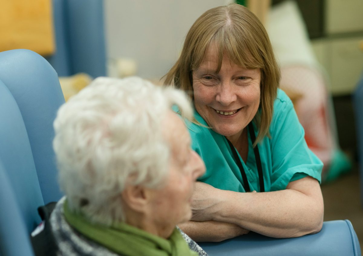 Care worker smiling with a resident in a care setting
